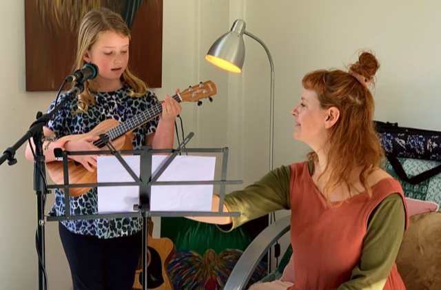 Student playing ukulele with Melody